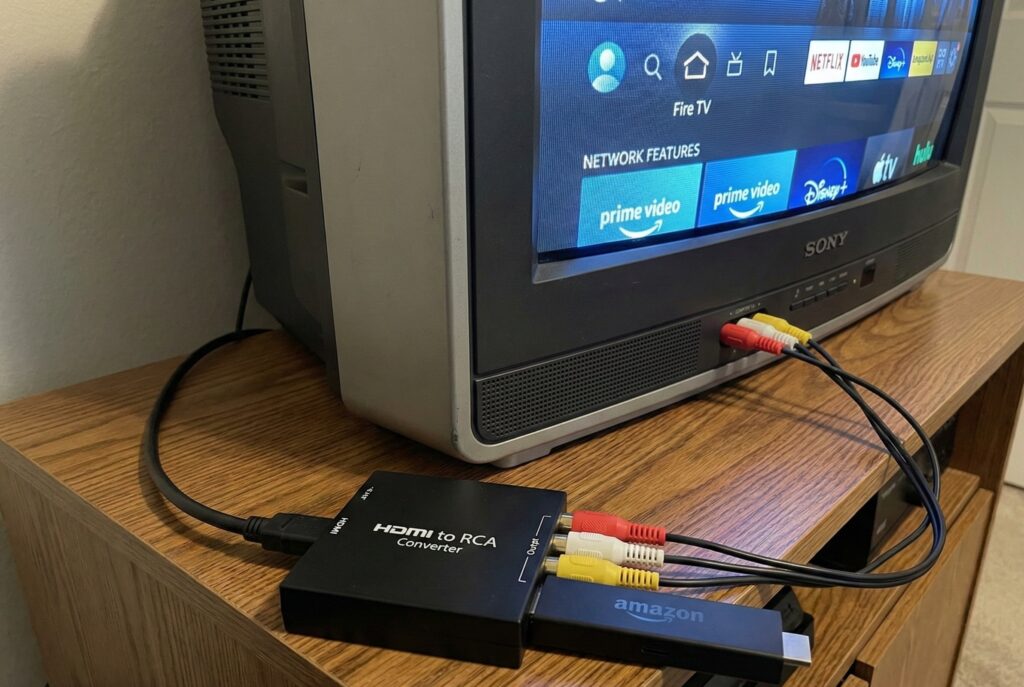 Conversor HDMI-RCA conectado mostrando cabos (vermelho/amarelo/branco)